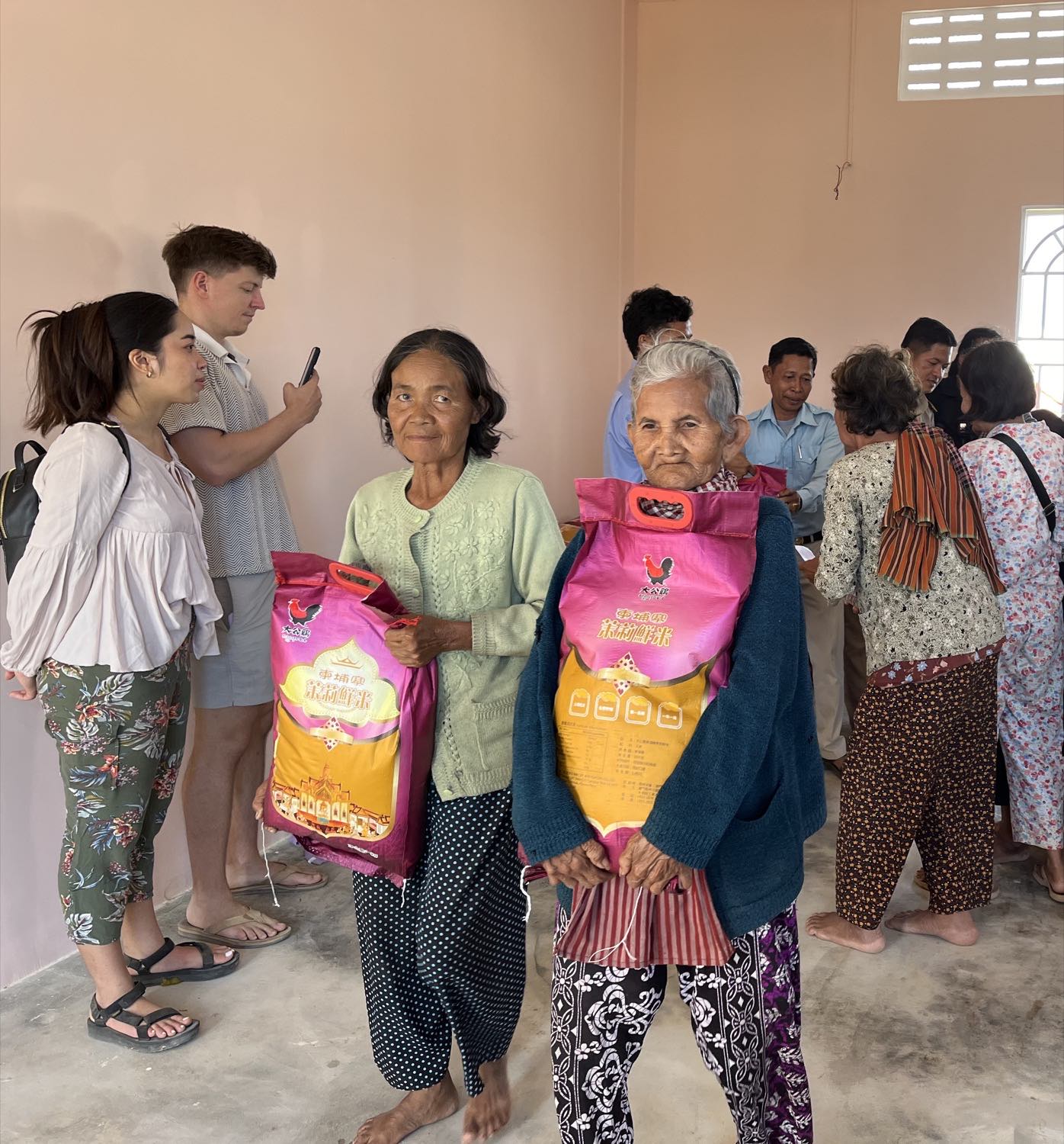 Two women holding sacks of rice they have just received