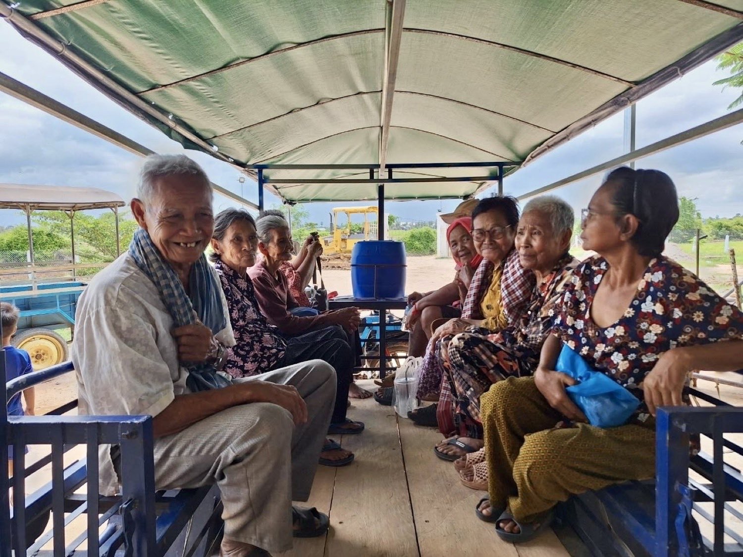 Older members of the community riding together in a covered cart on the way to a gathering
