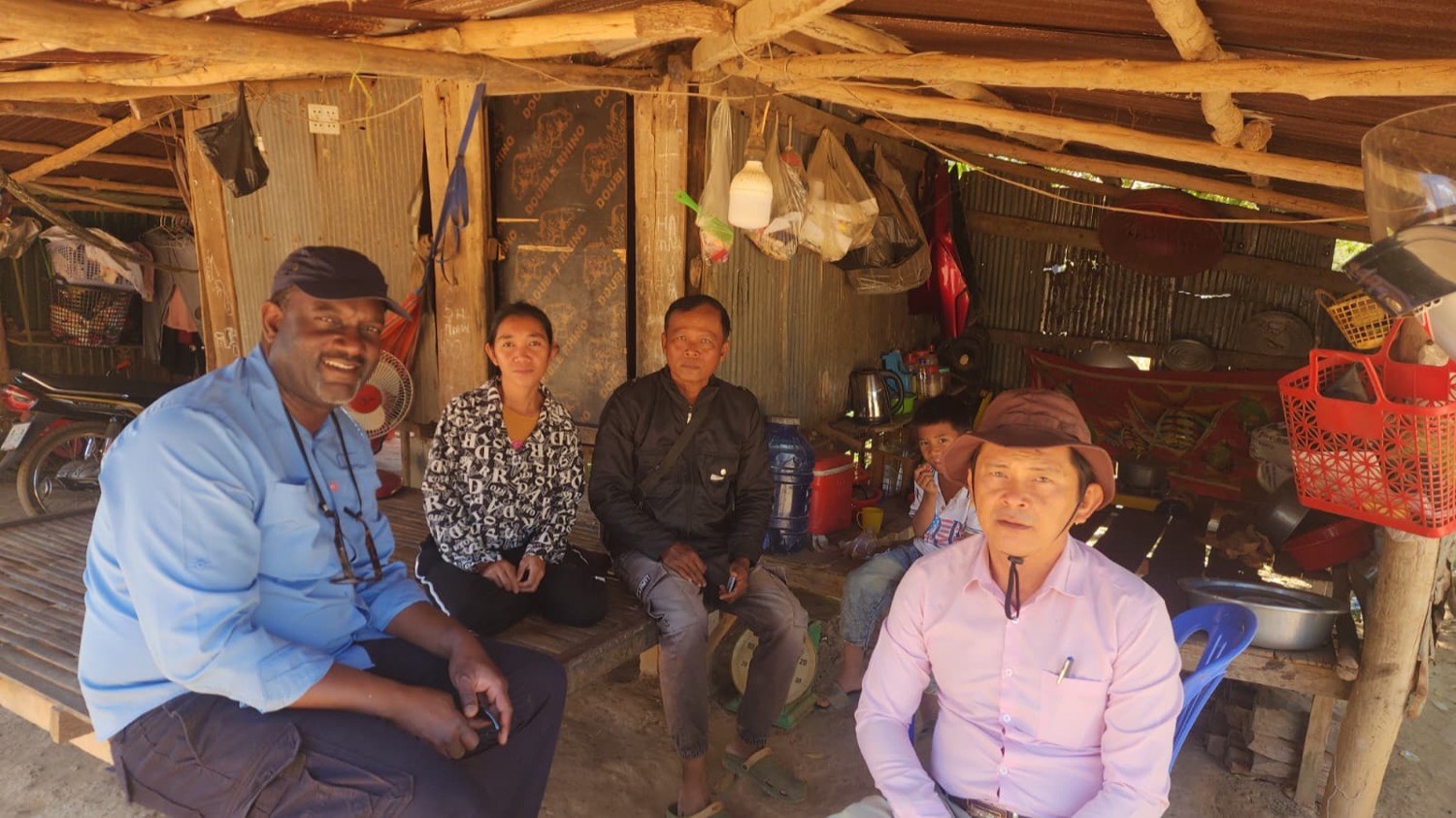 A family sitting together in their home during a visit from a local pastor and the team