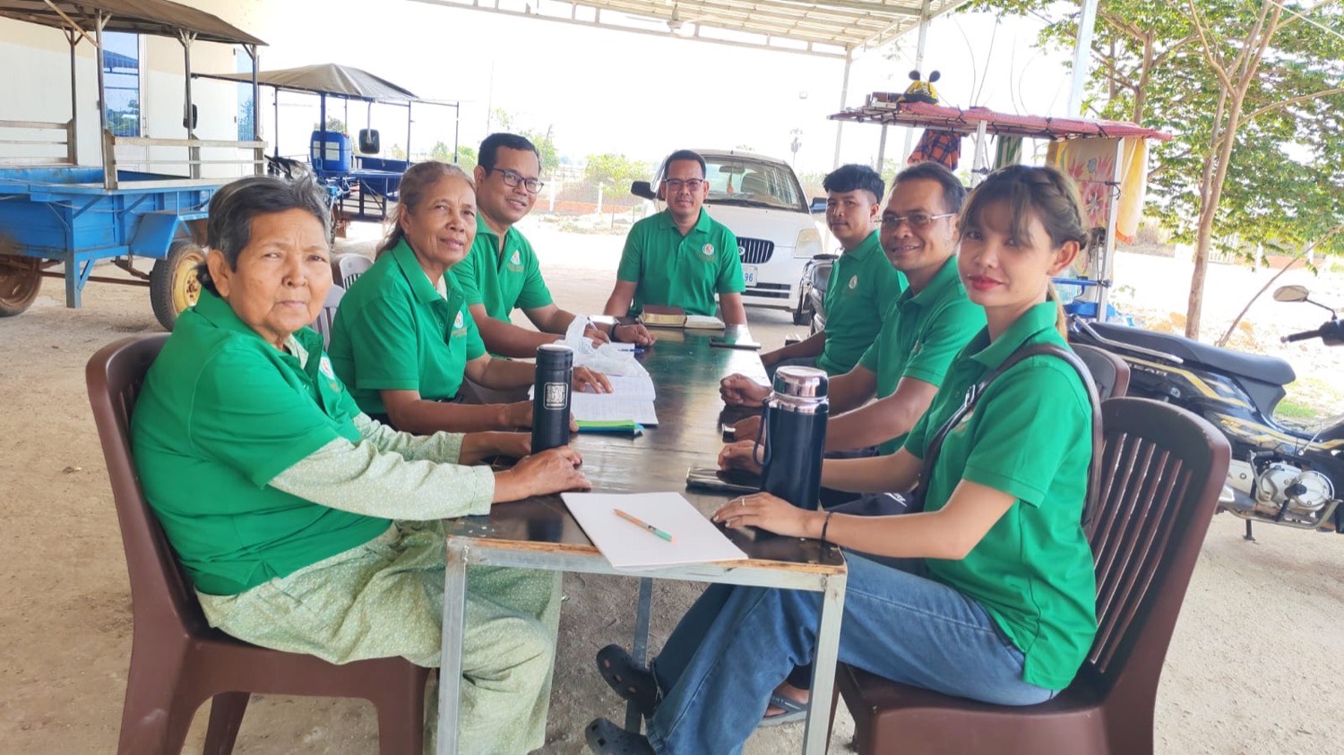 Members of the Cambodia team meeting around a table on the ministry property
