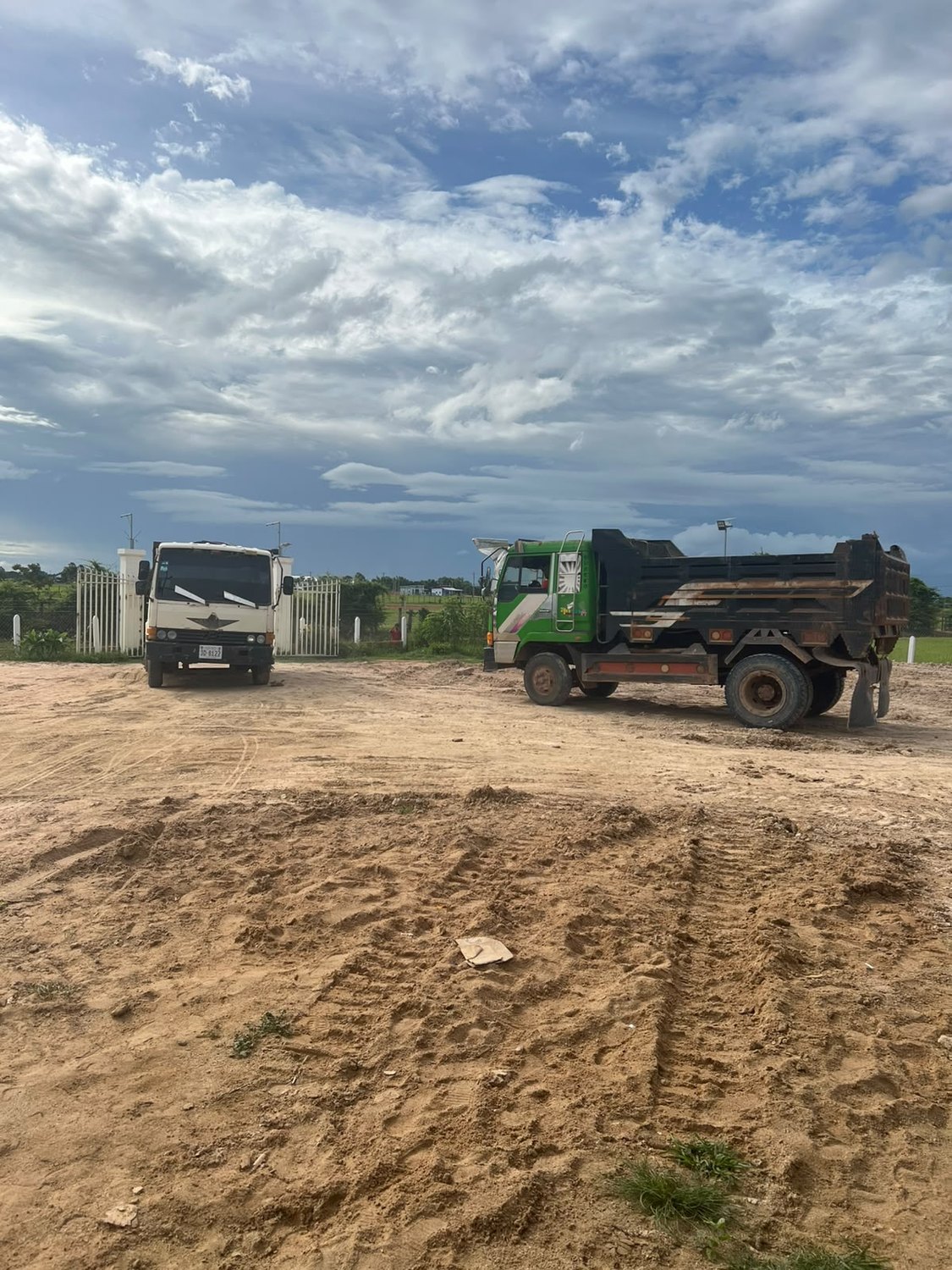 Two dump trucks standing on the newly raised ground at the ministry property