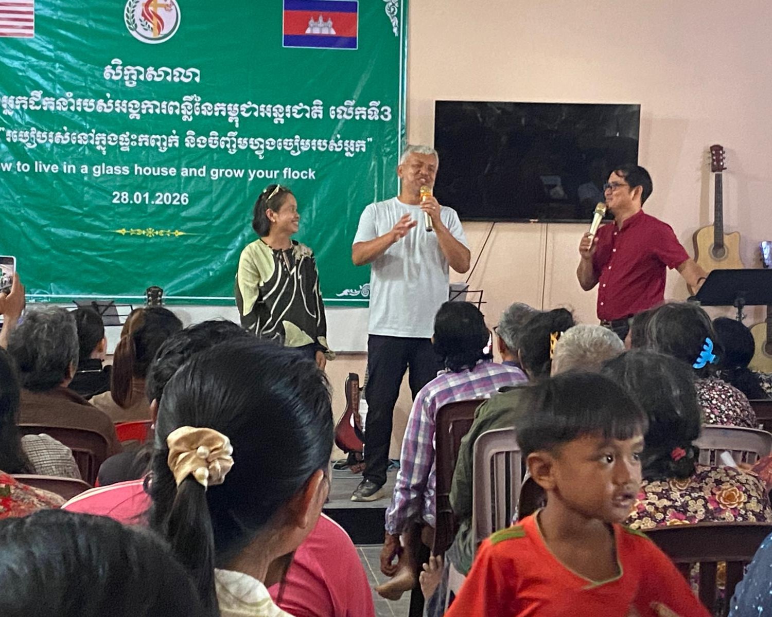 Two Cambodian leaders speaking to the congregation during a leadership training session at the church in Pursat